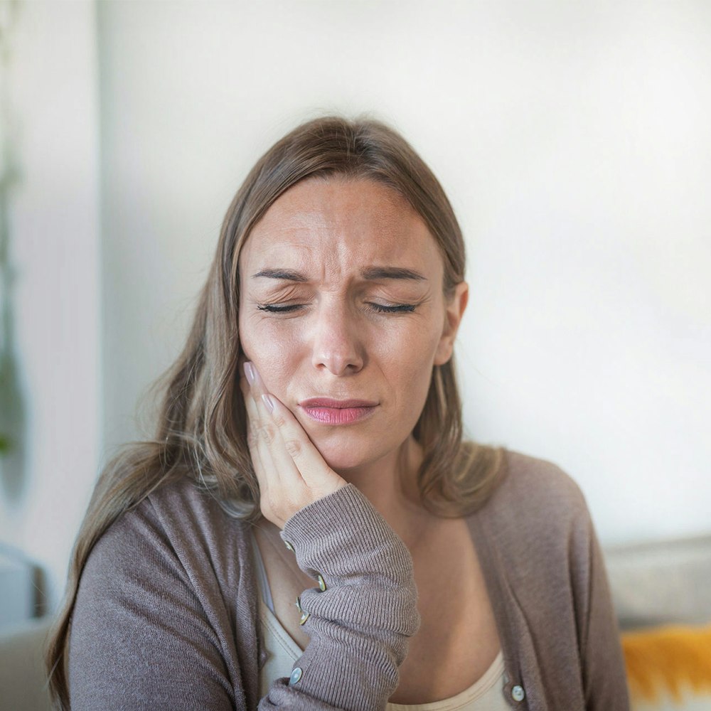 Woman clutching jaw in pain