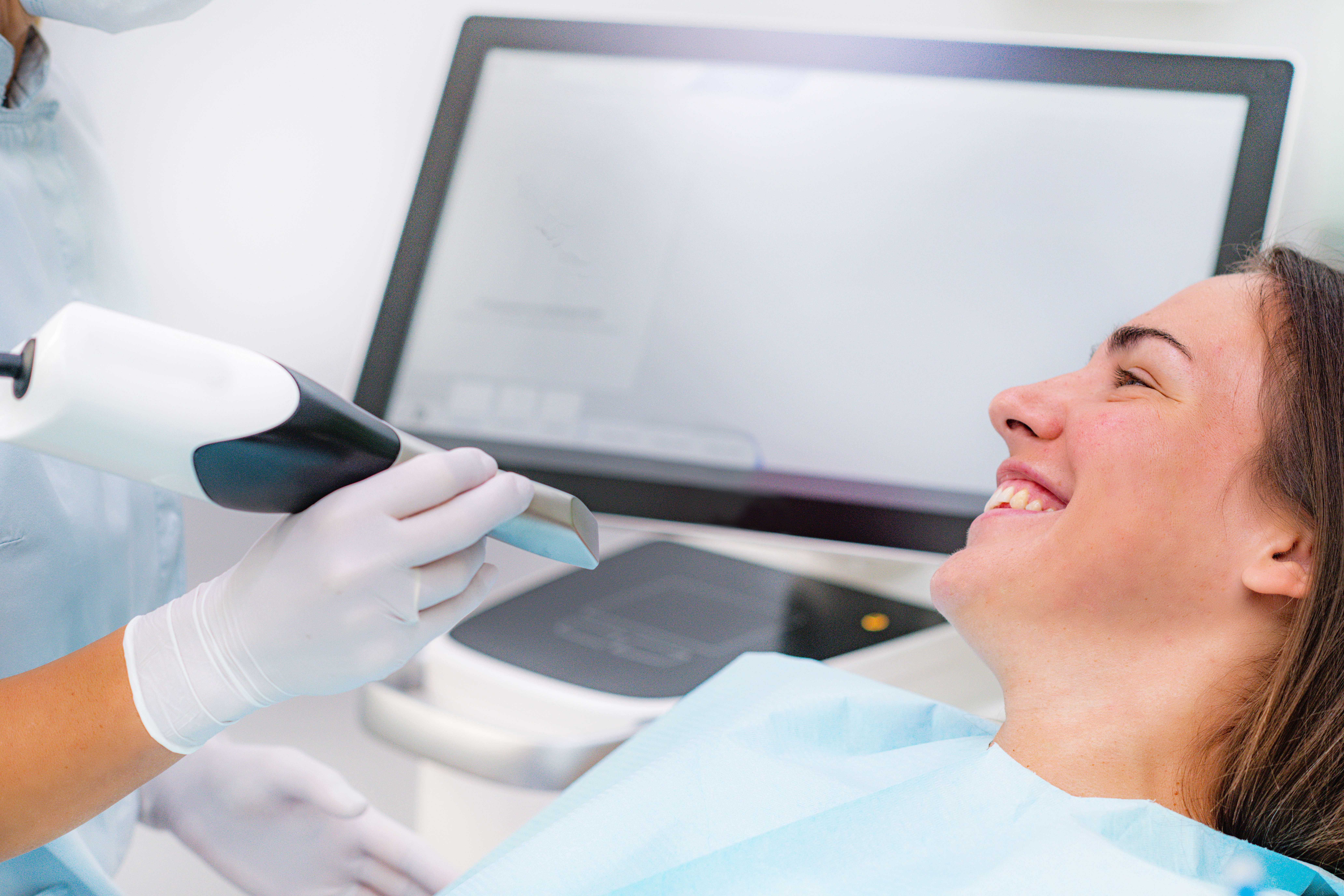 Patient smiling as dentist is about to look at her teeth with the iTero scanner
