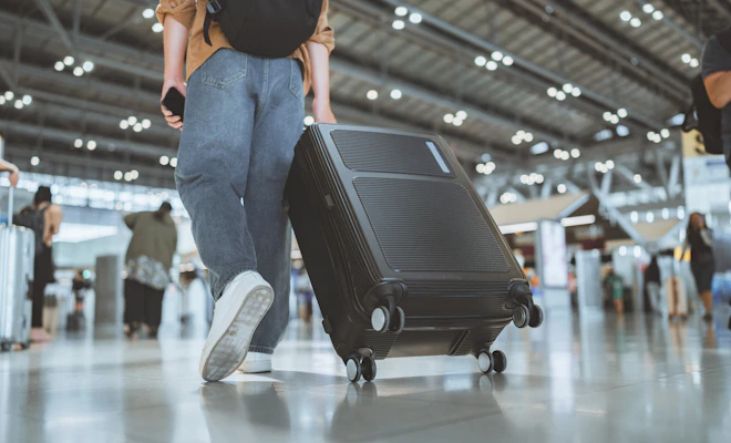 close-up of man carrying his luggage through the airport