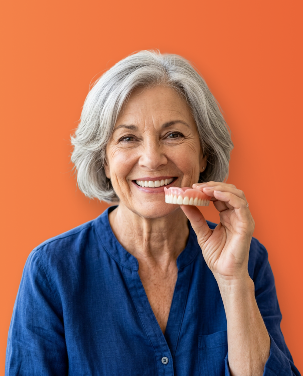 Senior woman holding the top arch of an implant denutre