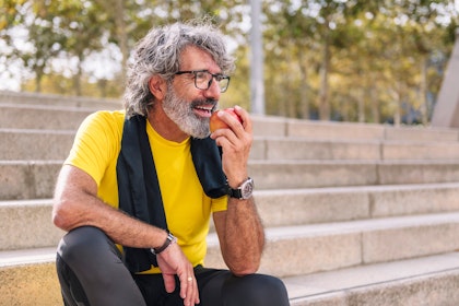 Man sitting on steps eating an apple