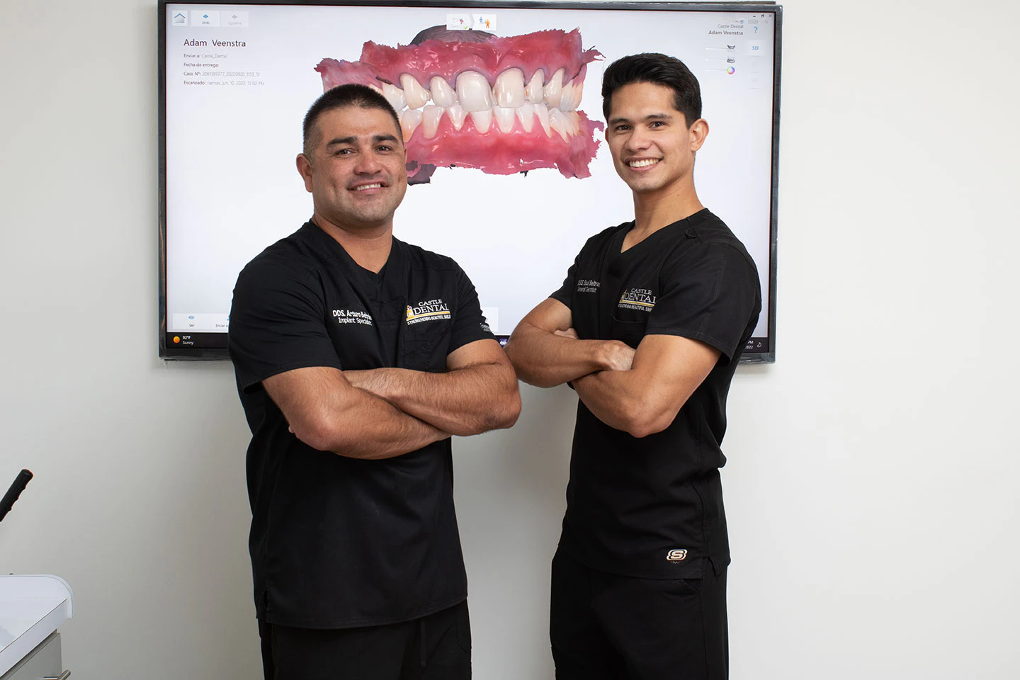 our dentists smiling in front of a digital model of a patient