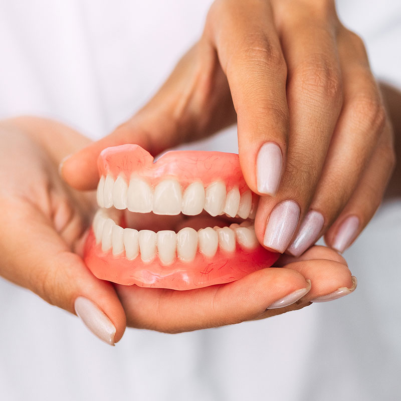 woman holding dentures