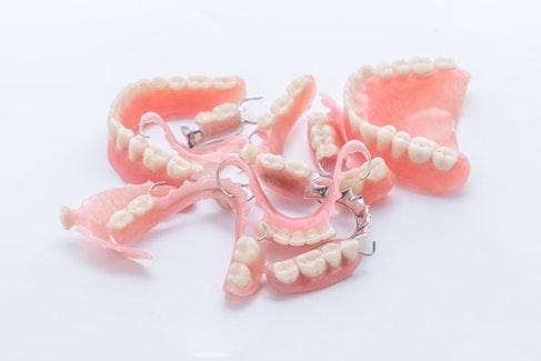 sets of full and partial dentures in a pile