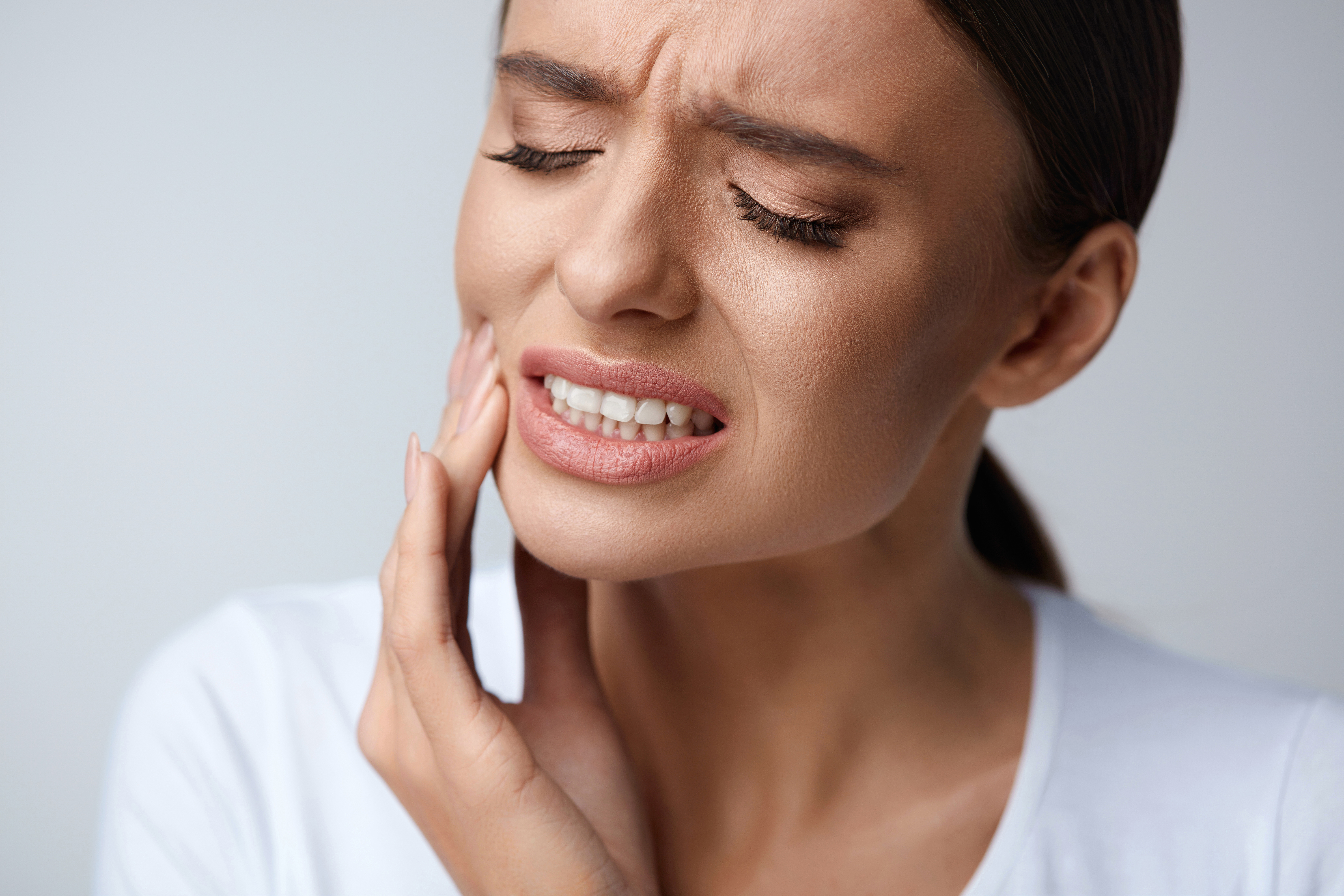 Woman holding jaw in pain
