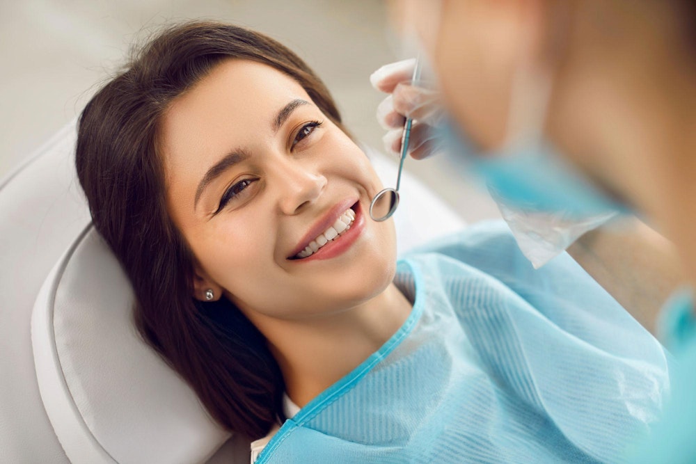 Smiling woman having her teeth examined