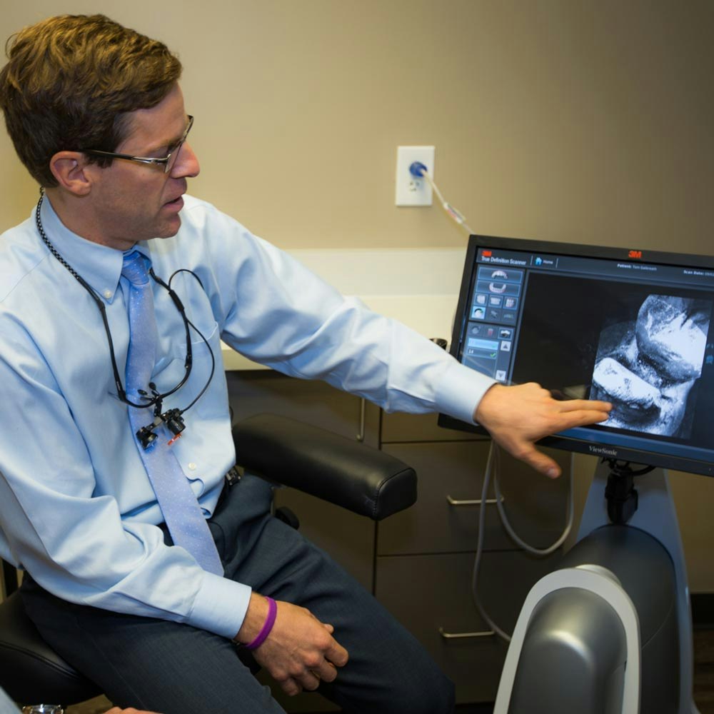 Dr. Travis Watson looking at a digital scanner with patient