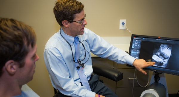 Dentist and patient looking at imaging