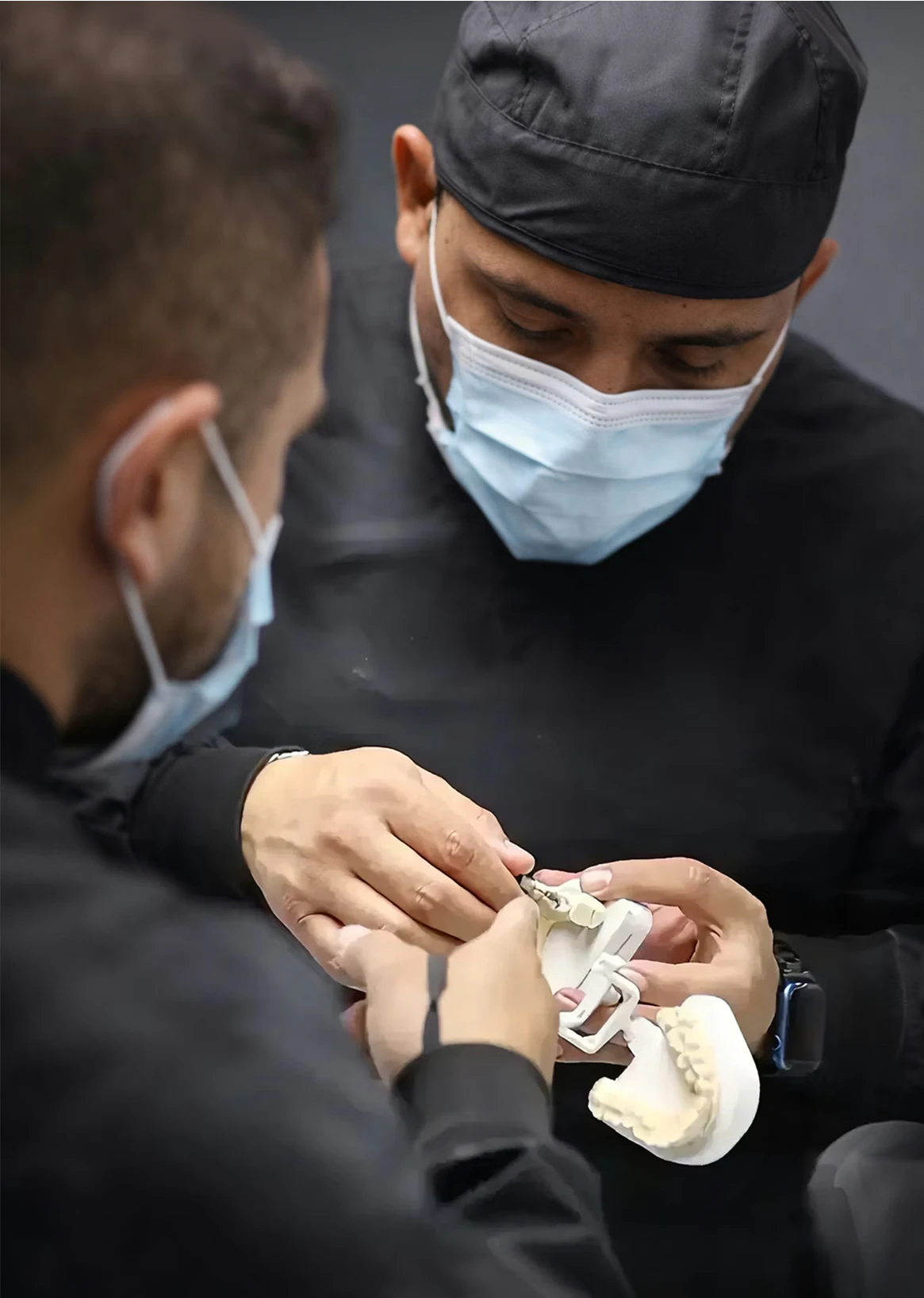 our dentists looking at a dental arch model