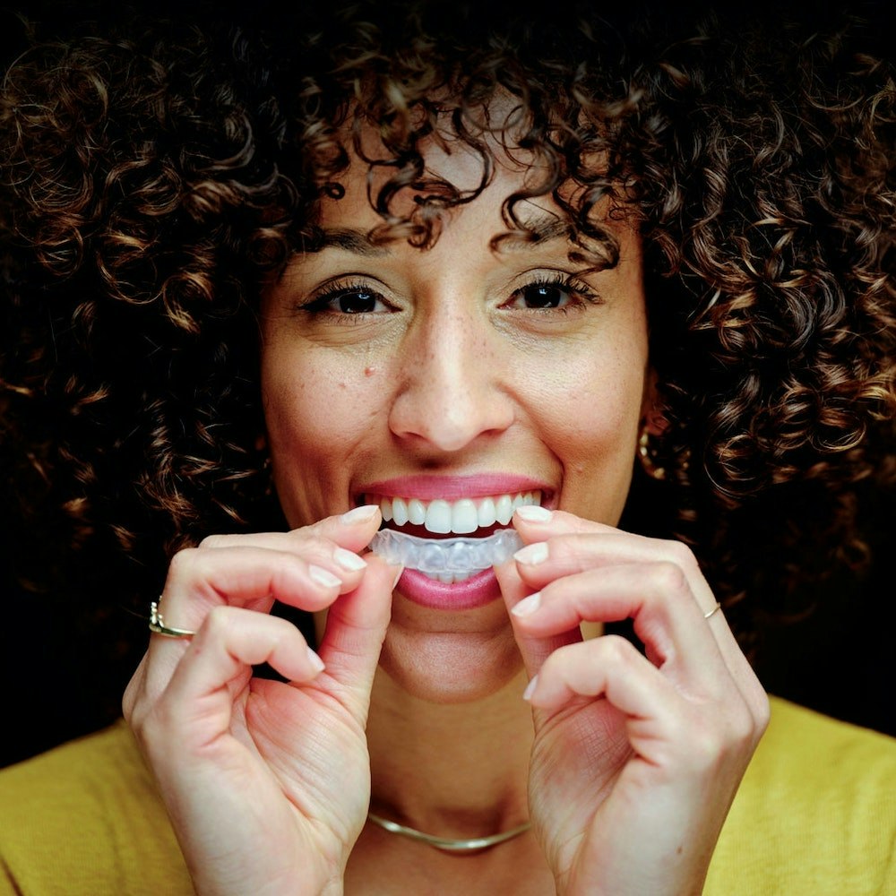 Woman putting in an Invisalign tray