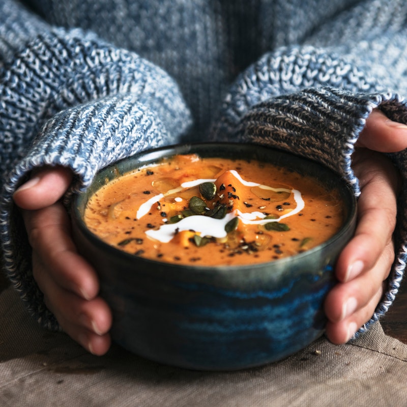 Person holding a bowl of soup