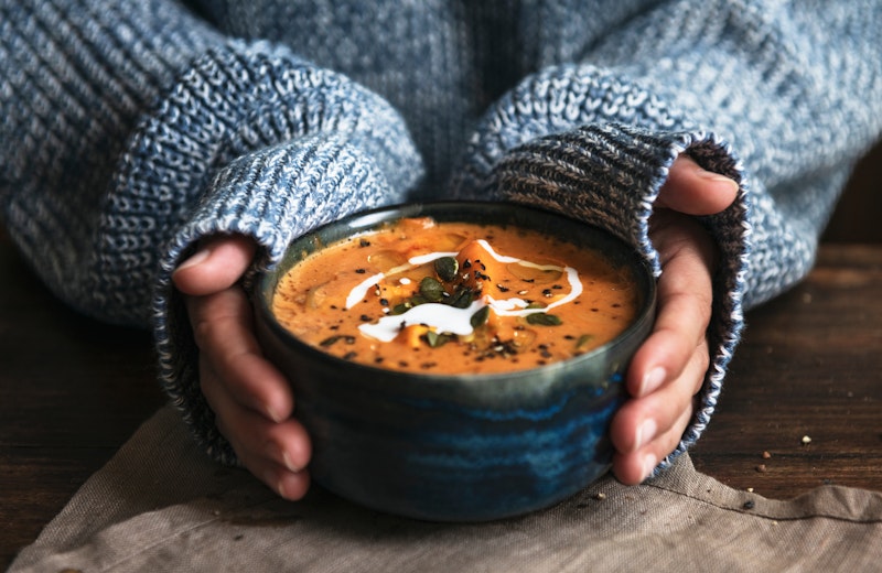 Person holding a bowl of soup