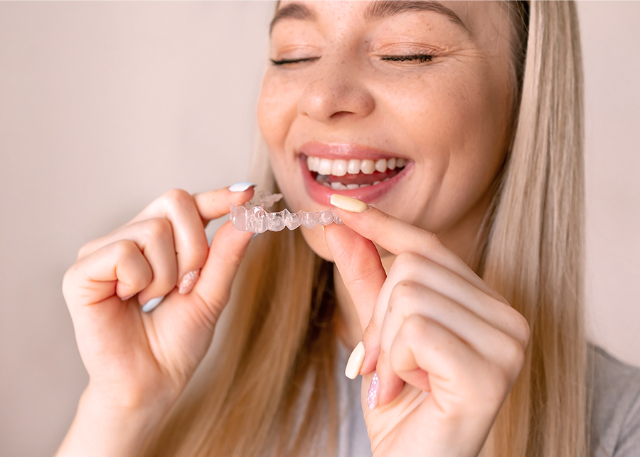 Smiling woman putting in Invisalign try