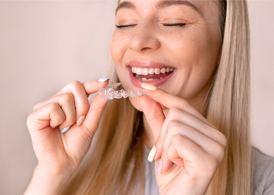 Smiling woman putting in Invisalign try
