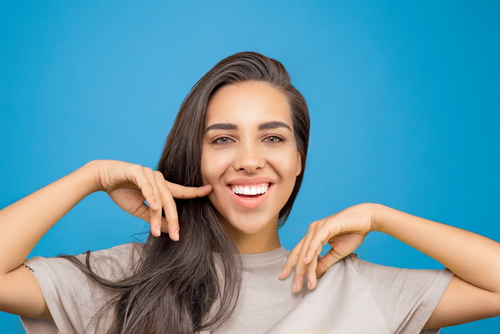 girl smiling, pointing at her cheek