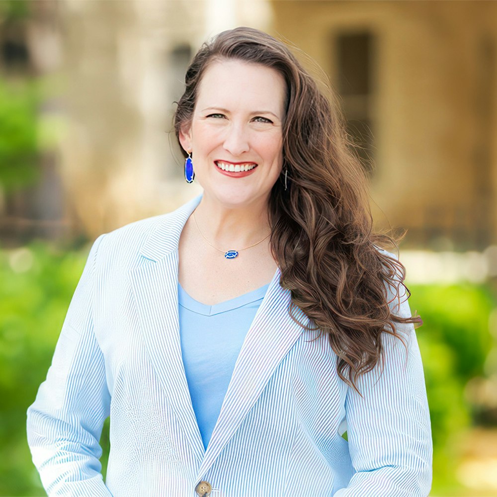 Dr. Jovan in a white and blue striped jacket