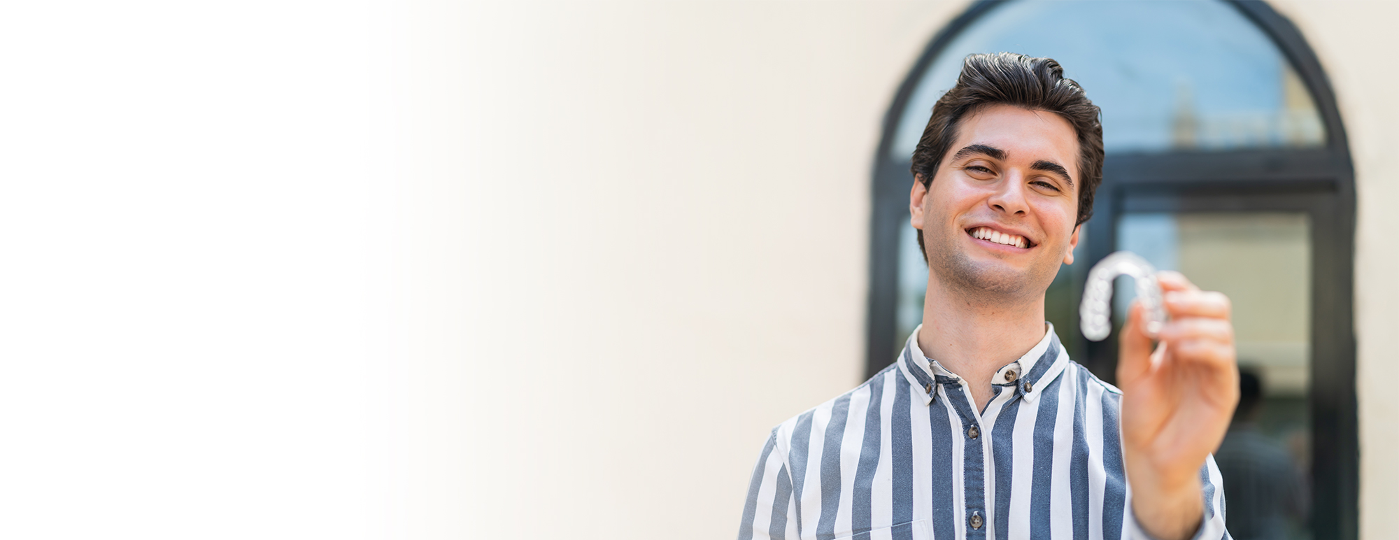 Young man holding clear aligners