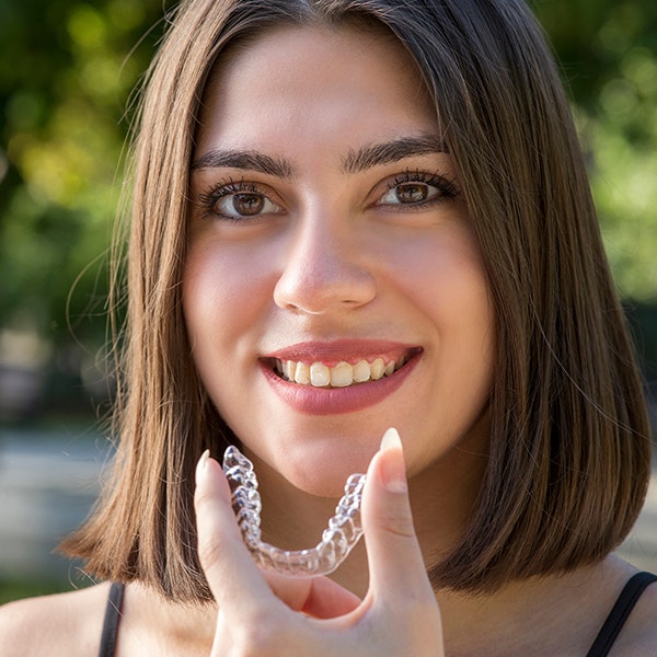Woman holding clear aligner