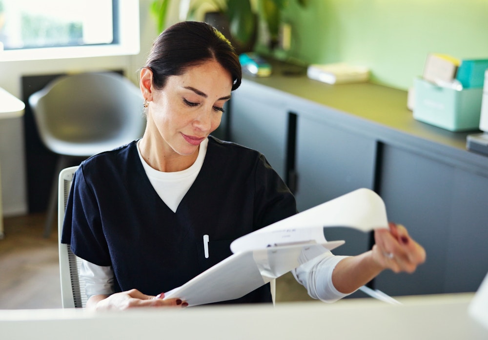 Dental clinic receptionist looking at forms