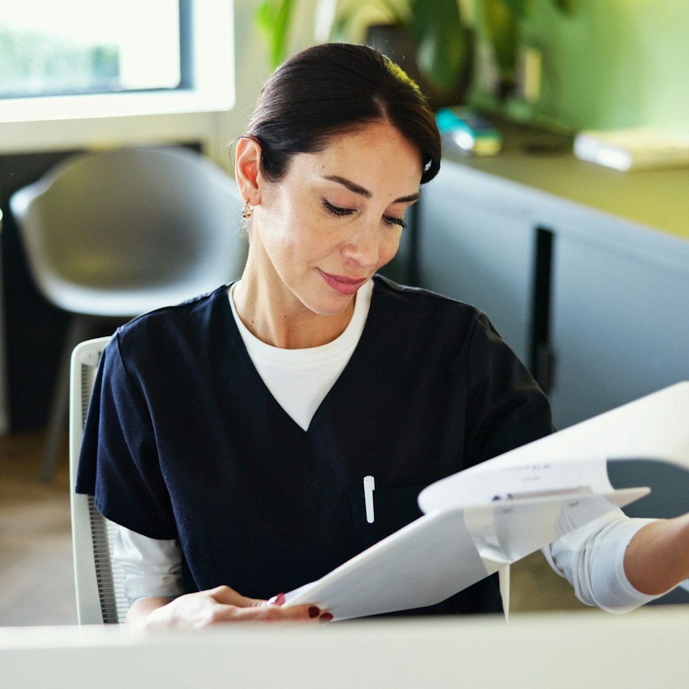 Dental clinic receptionist looking at forms