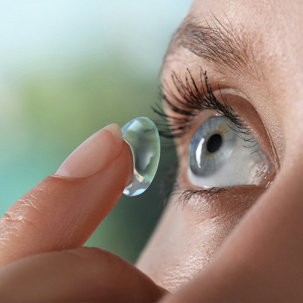 a woman applying a contact lens