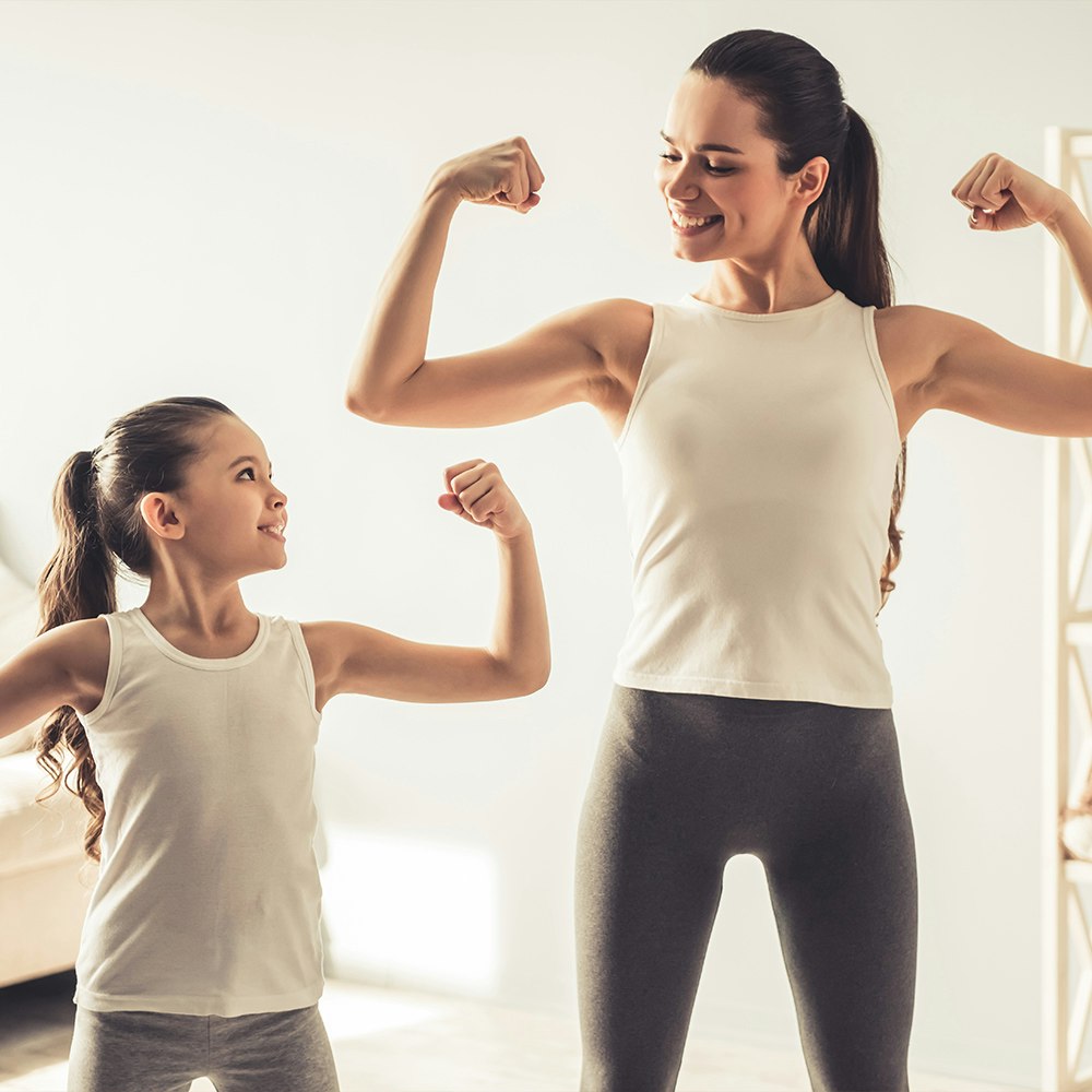 a mother and daughter flexing their biceps