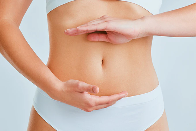 Woman framing her flat, toned abdomen with her hands