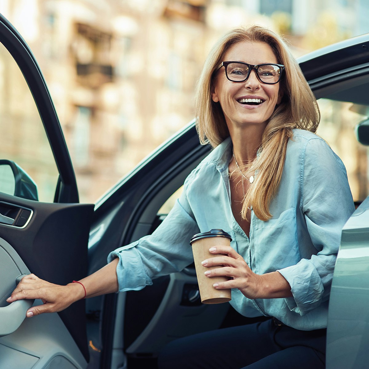 woman exiting car with a smile