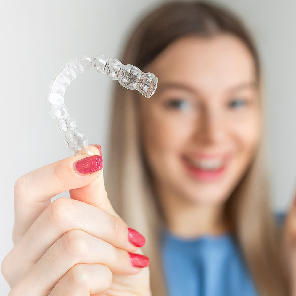 Woman holding clear aligner