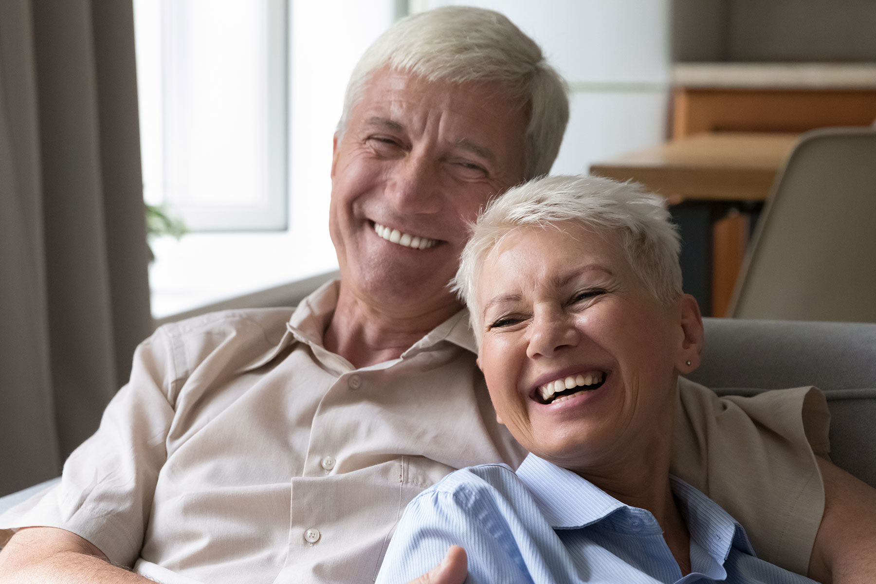 Older couple smiling on the couch