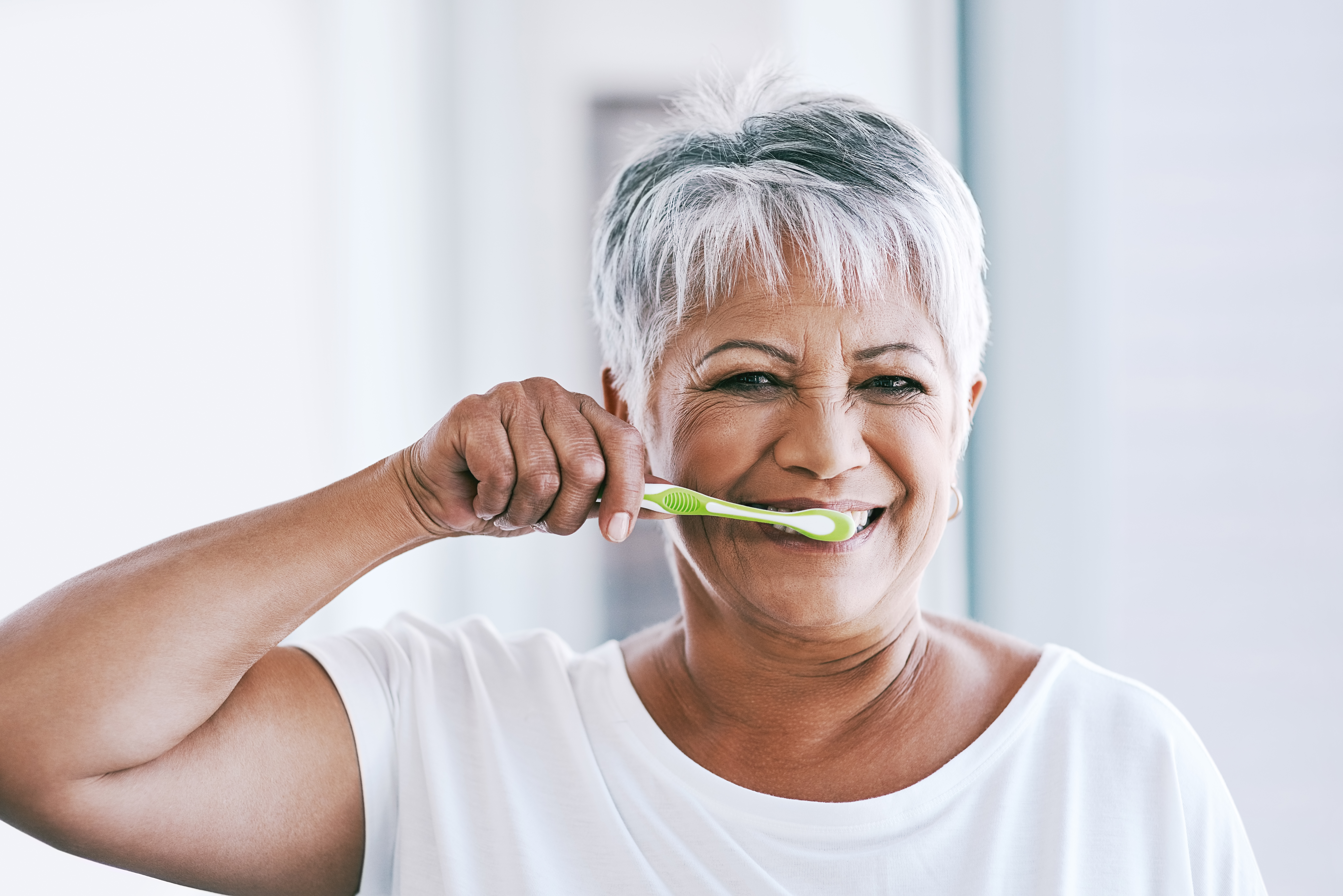 Older woman brushing her teeth