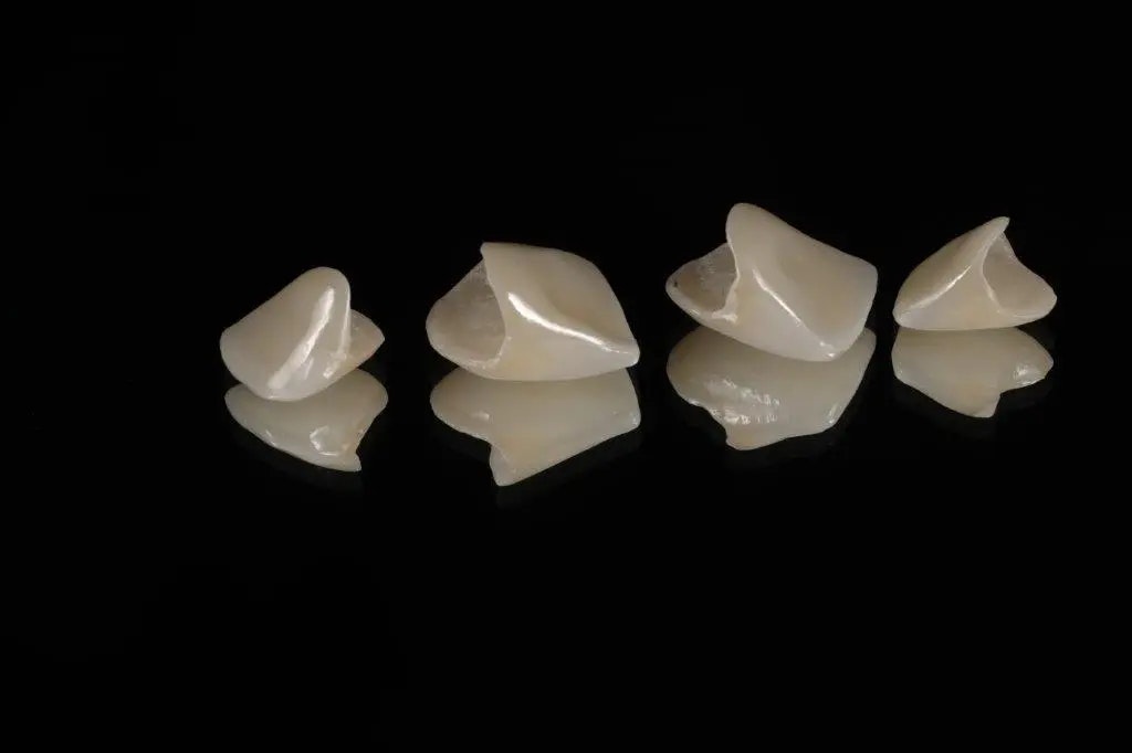 loose dental crowns against a black background