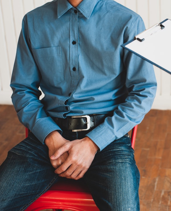 Man sitting with hands in lap at doctor's office