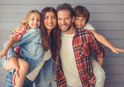 young family of four smiling