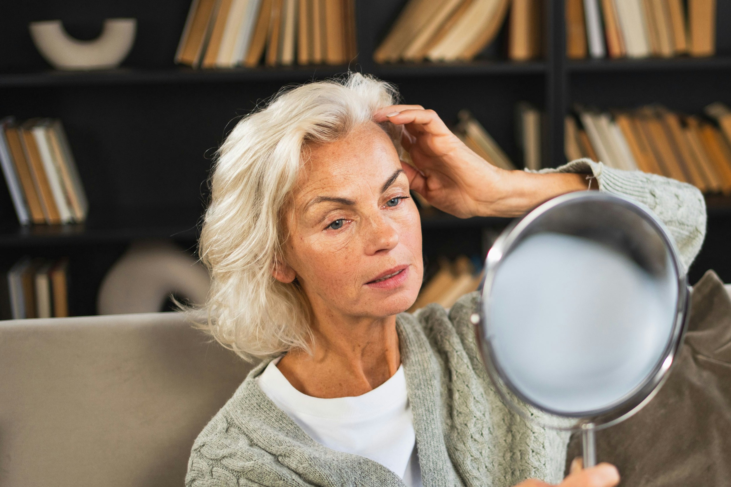 Woman looking at her eyebrows in the mirror