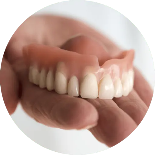 hand holding a pair of dentures