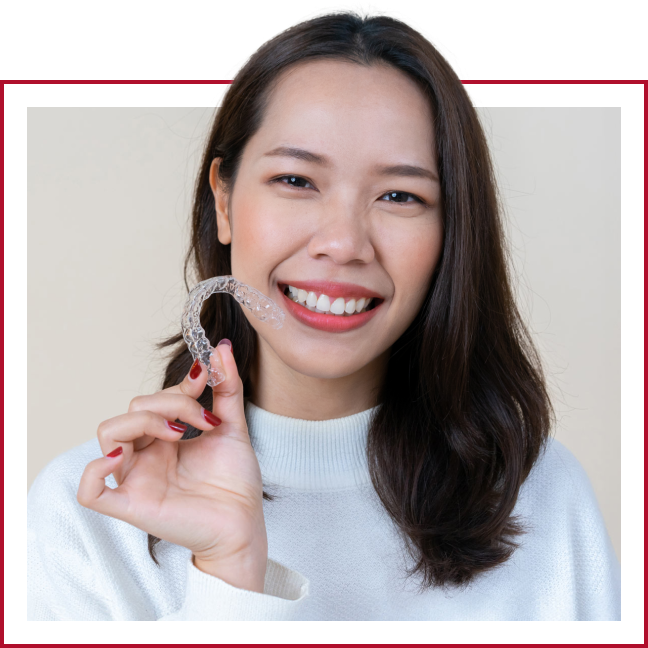 Smiling woman holding Invisalign