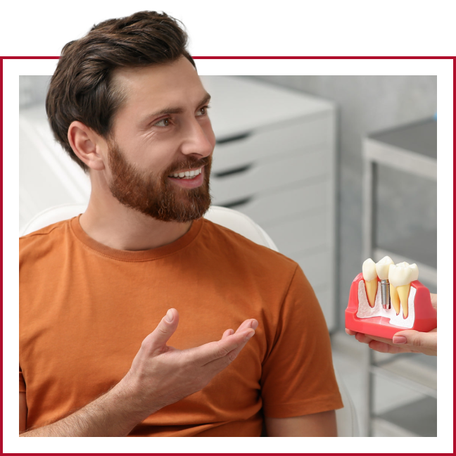 Man discussing model of dental implant