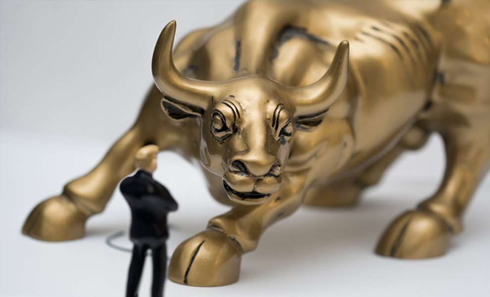 Figurine of a lawyer up against a giant gold bull