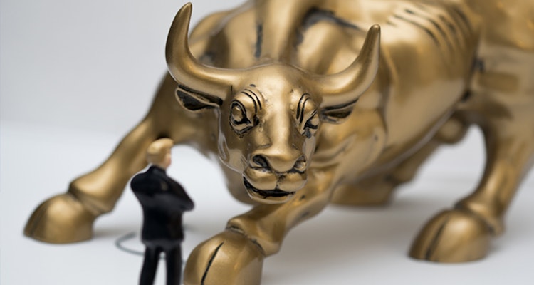 Figurine of a lawyer up against a giant gold bull