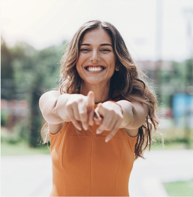 woman smiling and pointing at camera