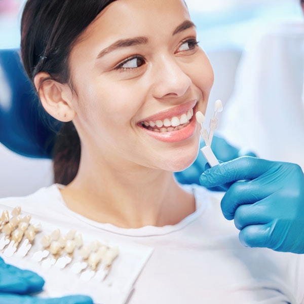 Woman getting shade matched for veneers