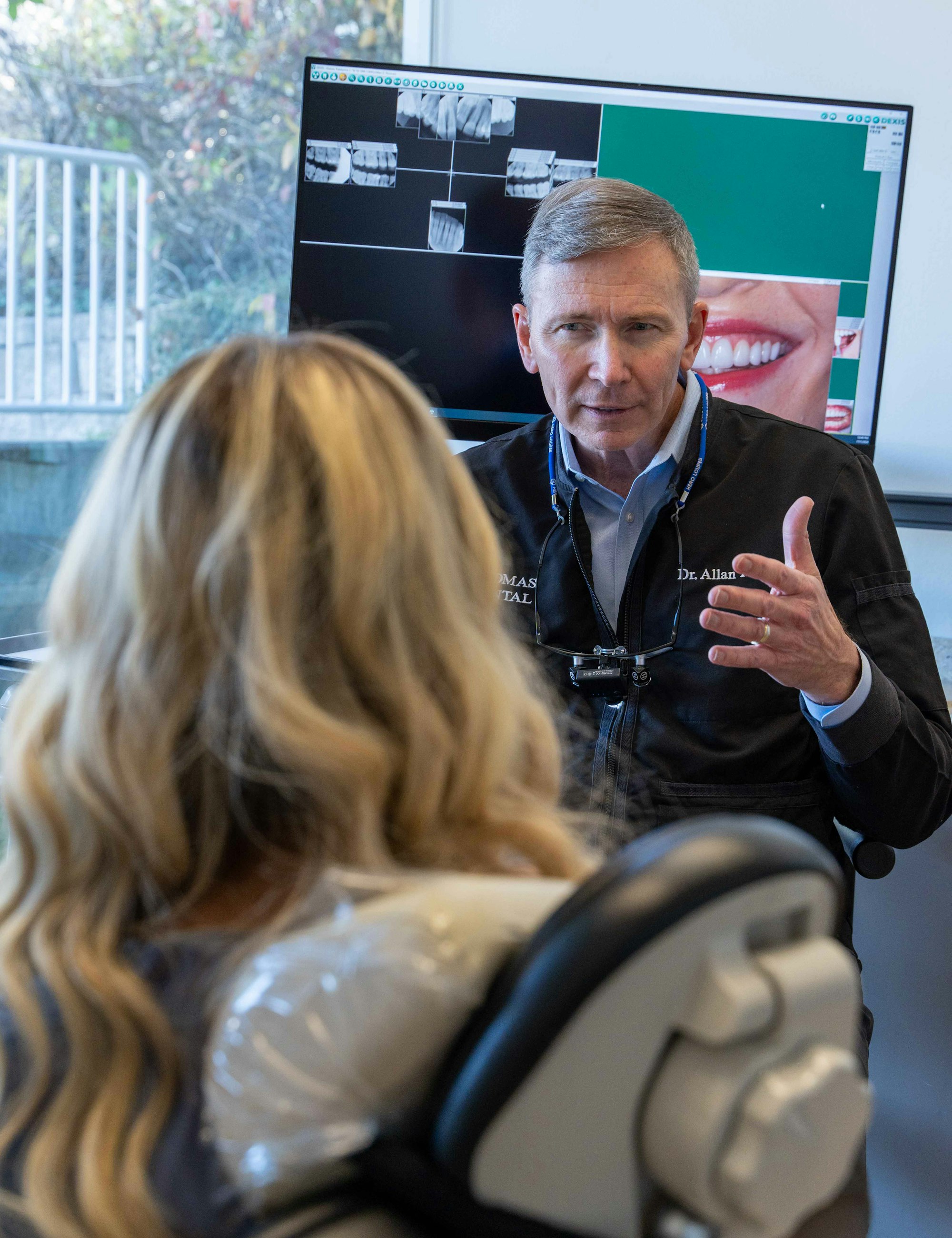 Dentist Allan S. Thomas educating a patient