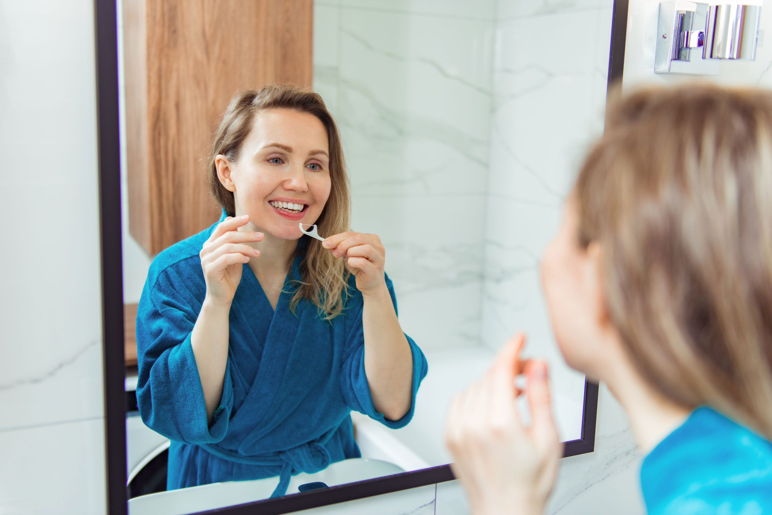 woman flossing with a floss threader