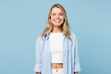 Woman smiling against a blue background