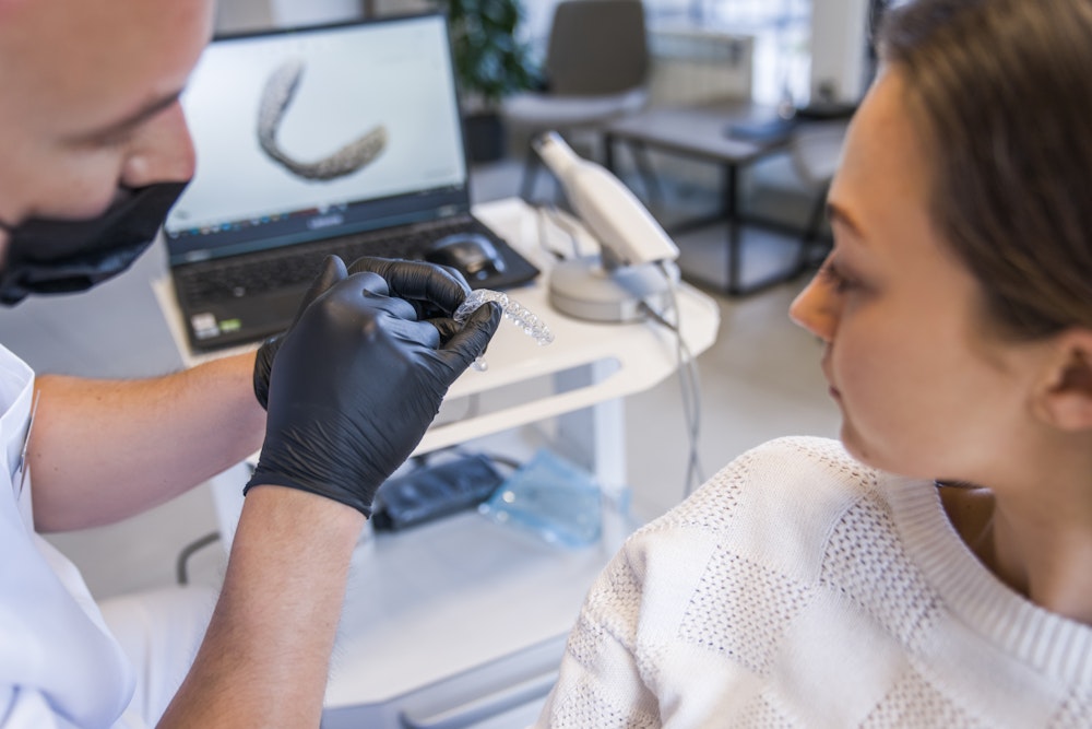 dentist showing patient a whitening tray