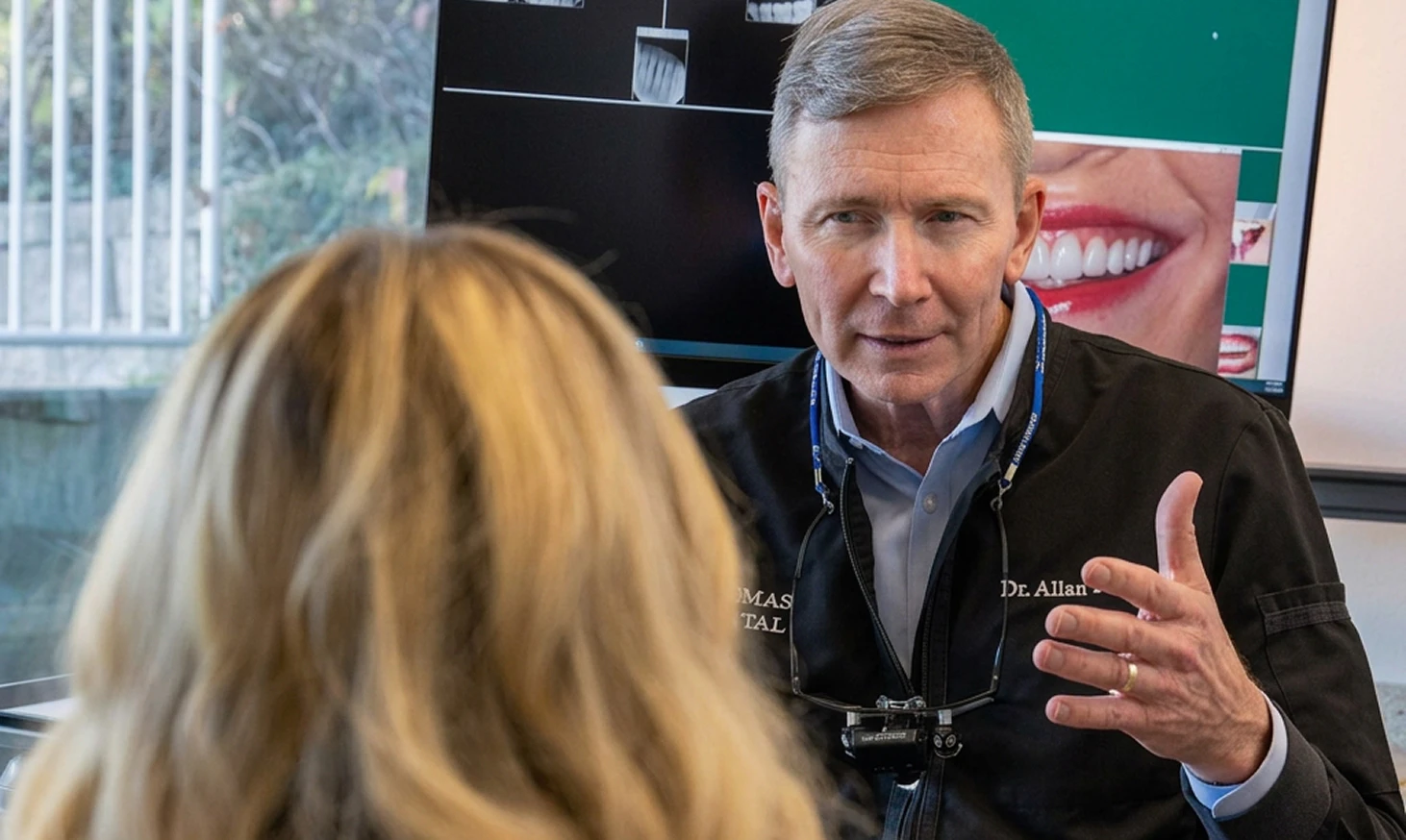 Allan S. Thomas speaks to patient