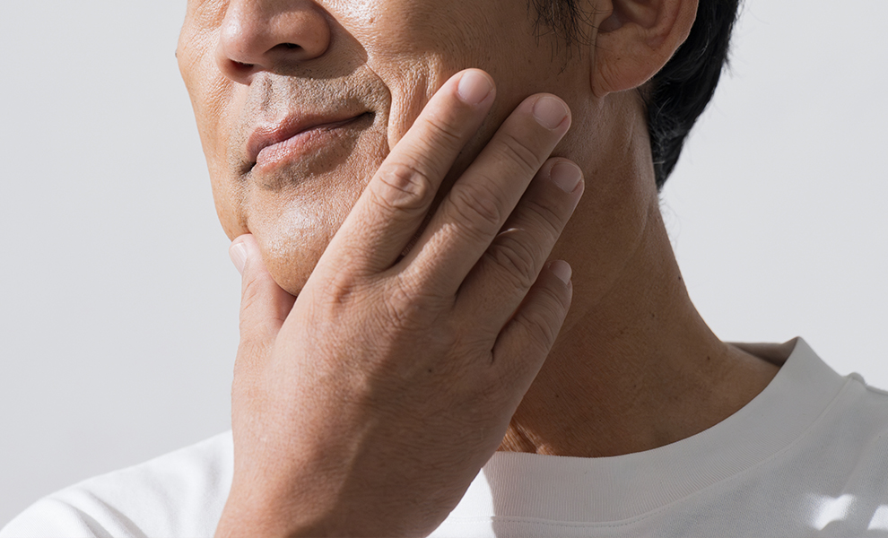 Middle aged man touching jawbone