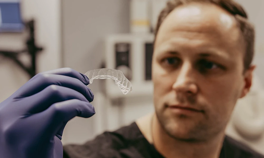 Dr. Chandler looking at an Invisalign in hand