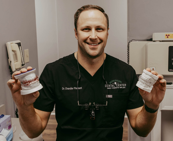 dentist holding models of dental arches